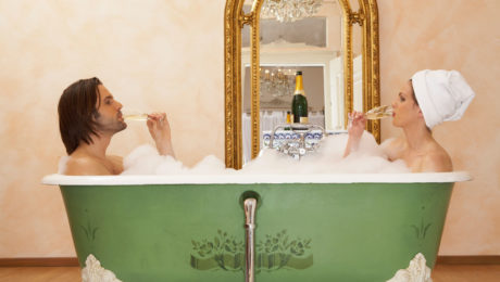 young couple sitting in bath drinking champagne, side view. Image shot 2007. Exact date unknown. valentines day treat